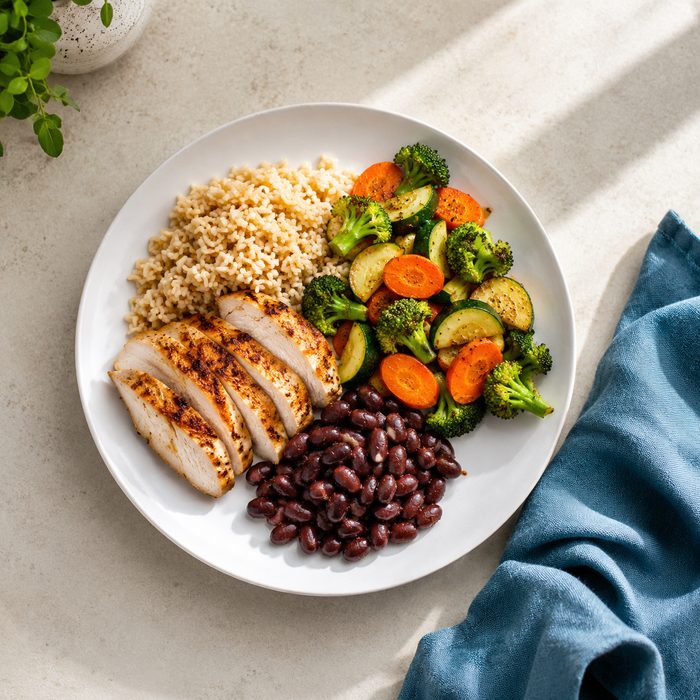 Almoço completo: frango grelhado, arroz integral, legumes e feijão